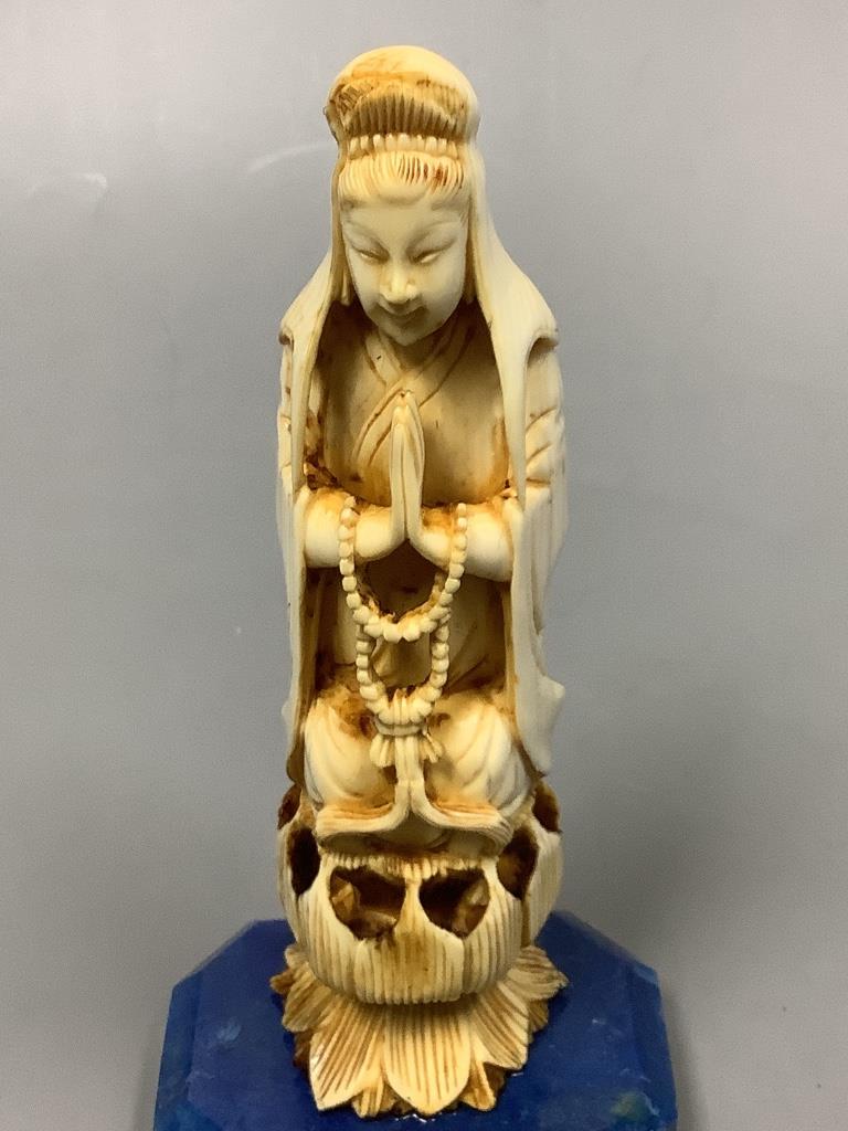 A 19th century Chinese carved ivory Guanyin, on a later lapis lazuli base, height 14cm